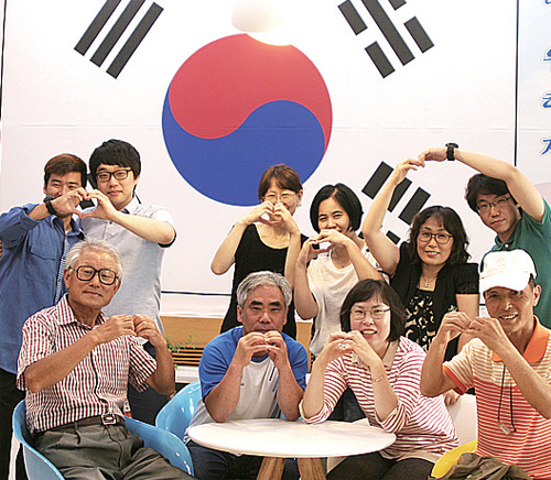 ▲ 지난 17일 과천시청사에 대형 태극기 현수막을 설치한 뒤 시민들이 나라사랑 마음을 담아 하트를 그리고 있다.