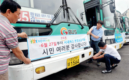 ▲ 내일부터 버스요금 오릅니다 25일 수원시 장안구 연무동 수원여객 차고지에서 버스회사 직원들이  27일부터 시행되는 경기도 시내버스 요금 인상을 알리는 안내문을 버스에 부착하고 있다. 전형민기자