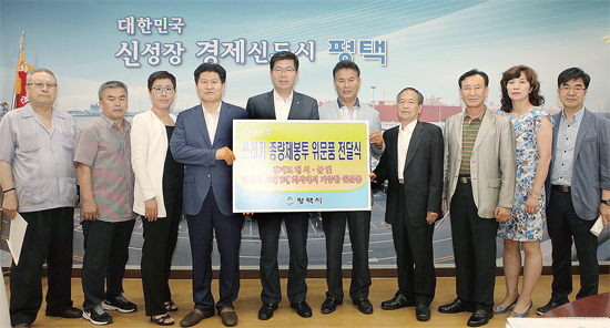 ▲ 공재광 평택시장이 7일 집무실에서 메르스 여파로 어려움을 겪고 있는 관내 위생업소지부에 쓰레기종량제봉투 기증식을 갖고 관계자들과 기념촬영을 하고 있다.  평택시 제공