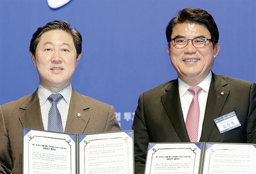 ▲ 유기준 장관(오른쪽)이 김성회 사장과 협약서를 교환한 뒤 포즈를 취하고 있다.