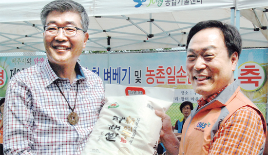 ▲ 원경희 여주시장(왼쪽)과 이필운 안양시장이 지난 1일 여주 첫 벼베기 행사 뒤 고품질 대왕님표 여주쌀을 전달하고 있다. 여주시 제공