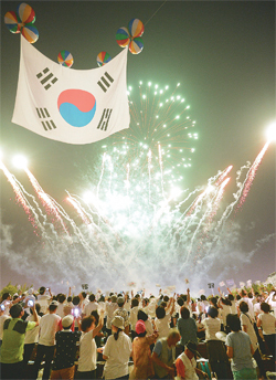 ▲ 광복절인 15일 수원 제1야외음악당에서 열린 ‘7,000인 시민대합창’에 참가한 시민들이 광복 70주년을 축하하는 폭죽쇼를 관람하고 있다.  오승현기자