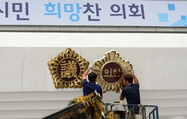 19일 오후 인천시의회가 직할시의회로 개원한지 24년만에 한자명패에서 한글로 변경해 청사 현관지붕에 설치 작업을 하고 있다./장용준기자