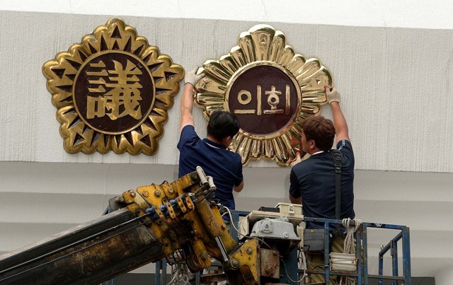 19일 오후 인천시의회가 직할시의회로 개원한지 24년만에 한자명패에서 한글로 변경해 청사 현관지붕에 설치 작업을 하고 있다./장용준기자