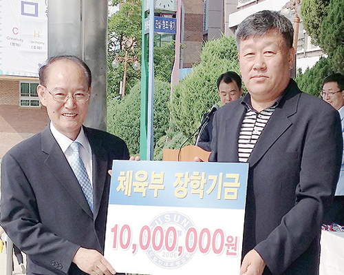 ▲ 수원 수성고등학교 운동장에서 31일 열린 장학금 수여식에서 박달양 동문회장(오른쪽)이 김국회 교장에 장학금 증서를 전달한 뒤 포즈를 취하고 있다.