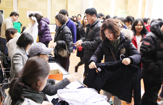 ▲ 공유사회네트워크가 올해신학기를 맞아 연 교복은행을 찾은학부모와 학생 등이 교복을고르고 있다.