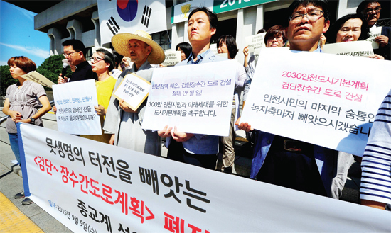 ▲ 9일 오전 인천지역 개신교와 불교, 천주교 종교인 단체 대표자들이 인천시청 현관 앞에서 검단~장수간 도로계획 폐지를 촉구하는 종교계 선언을 하고 있다. 장용준기자