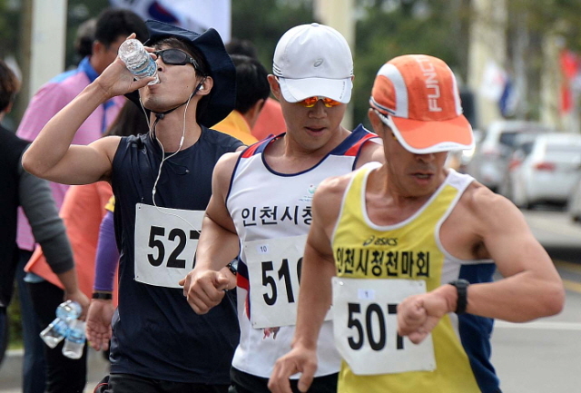 일반부 선수들이 생수로 목을 축이며 중간 런닝타임을 확인하고 있다. 장용준기자