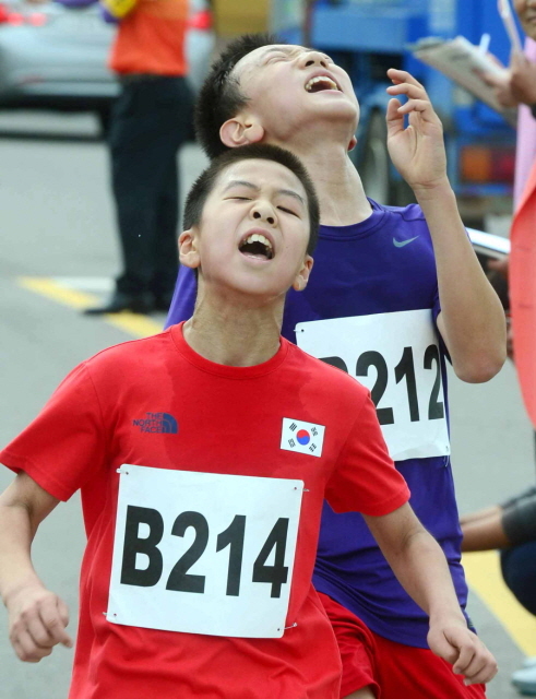12일 오전 인천시 중구 월미도 순회도로에서 열린 제65주년 9.15 인천상륙작전 전승기념 마라톤대회에서  학생부 참가 선수들이 순위다툼을 벌이며 결승선을 통과하고 있다. 김시범기자