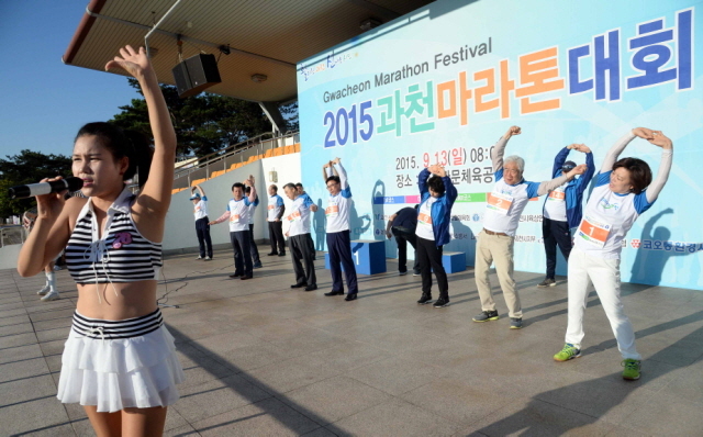 13일 과천 관문체육공원 운동장에서 열린 ‘2015 과천 마라톤 대회’에서  출발에 앞서치어리더가 몸풀기 운동 시연을 하고있다. 전형민기자