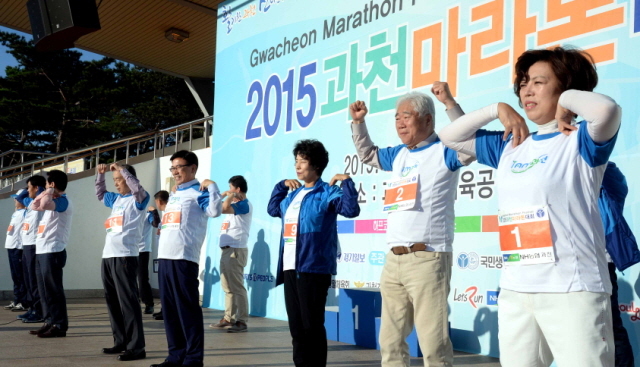 13일 과천 관문체육공원 운동장에서 열린 ‘2015 과천 마라톤 대회’에서 출발에 앞서 신계용 과천시장, 이순국 경기일보 사장 등 내빈들이 참가자들과 함께 몸풀기 운동을 하고 있다.전형민기자