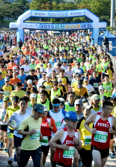 13일 과천 관문체육공원 운동장에서 열린 ‘2015 과천 마라톤 대회’에서 풀코스,하프코스,10km,5km에 참가한 마라토너들이 힘차게 운동장을 출발하고 있다.전형민기자