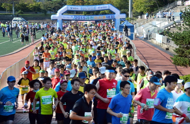 13일 과천 관문체육공원 운동장에서 열린 ‘2015 과천 마라톤 대회’에서 풀코스,하프코스,10km,5km에 참가한 마라토너들이 힘차게 운동장을 출발하고 있다.전형민기자