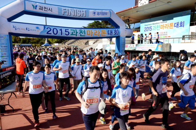 13일 과천 관문체육공원 운동장에서 열린 ‘2015 과천 마라톤 대회’에서 풀코스,하프코스,10km,5km에 참가한 마라토너들이 힘차게 운동장을 출발하고 있다.전형민기자