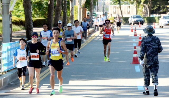 13일 과천 관문체육공원 운동장에서 열린 ‘2015 과천 마라톤 대회’에 참가한 마라토너들이 과천시가지를 힘차게 달리고 있다.전형민기자