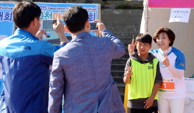 13일 과천 관문체육공원 운동장에서 열린 ‘2015 과천 마라톤 대회’에 참가한 어린이가 신계용 과천시장과 기념촬영을 하고  있다.전형민기자