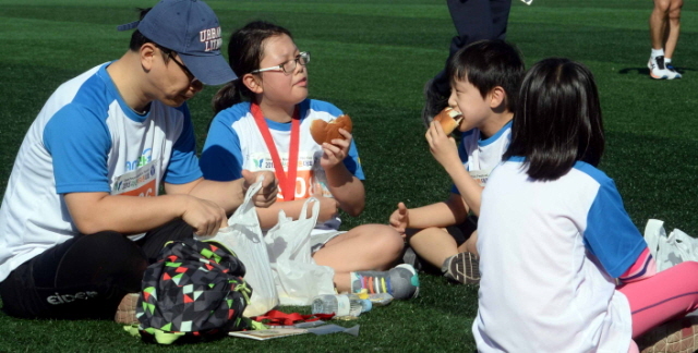 13일 과천 관문체육공원 운동장에서 열린 ‘2015 과천 마라톤 대회’에서  참가한 한 가족이 완주 후 간식을 맛있게 먹고  있다.전형민기자