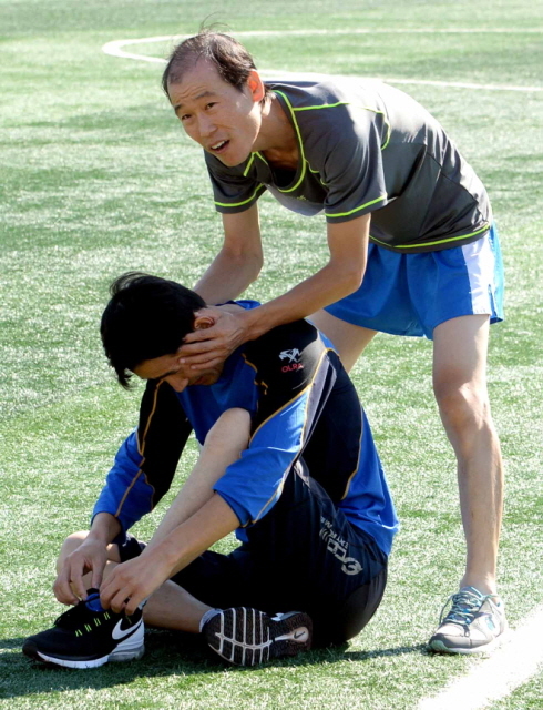 13일 과천 관문체육공원 운동장에서 열린 ‘2015 과천 마라톤 대회’에서 완주 후 탈진한 참가자에게 안마를 해주고 있다.전형민기자