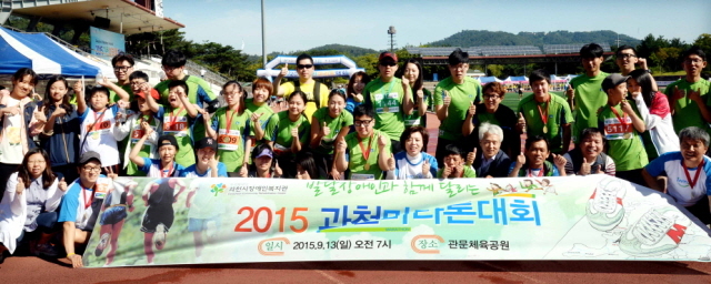 13일 과천 관문체육공원 운동장에서 열린 ‘2015 과천 마라톤 대회’에 참가한 과천시장애인복지관 참가자들이 완주 후 기념촬영을 하고 있다.전형민기자