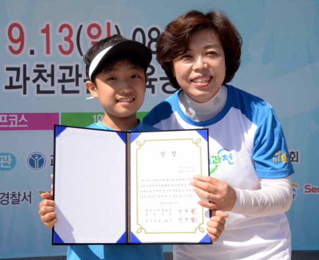 13일 과천 관문체육공원 운동장에서 열린 ‘2015 과천 마라톤 대회’에서 신계용 과천시장이 이동혁 어린이에게 특별상을 시상하고 있다.전형민기자