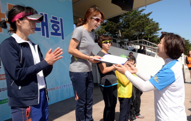 13일 과천 관문체육공원 운동장에서 열린 ‘2015 과천 마라톤 대회’에서 신계용 과천시장이 여자 10km 입상자에 대한 시상을 하고 있다.전형민기자