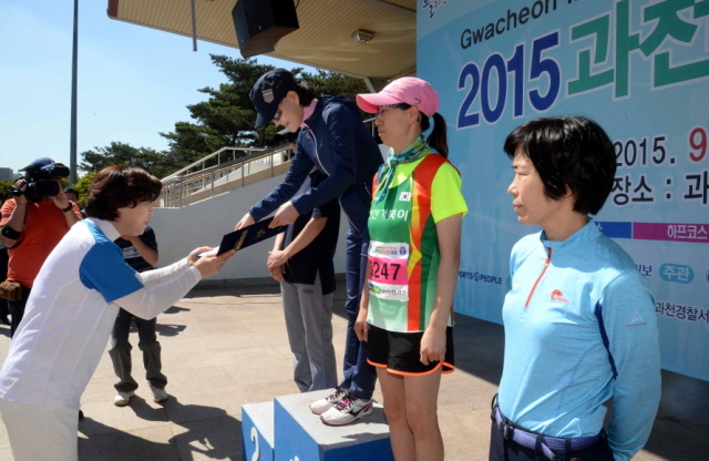 13일 과천 관문체육공원 운동장에서 열린 ‘2015 과천 마라톤 대회’에서 신계용 과천시장이 여자 하프코스 입상자에 대한 시상을 하고 있다.전형민기자