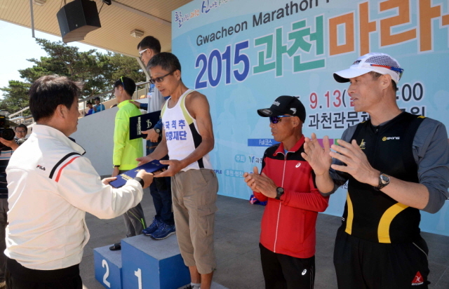 13일 과천 관문체육공원 운동장에서 열린 ‘2015 과천 마라톤 대회’에서  남자 풀코스 입상자에 대한 시상을 하고 있다.전형민기자