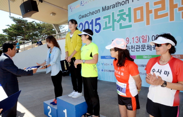 13일 과천 관문체육공원 운동장에서 열린 ‘2015 과천 마라톤 대회’에서  여자 풀코스 입상자에 대한 시상을 하고 있다.전형민기자