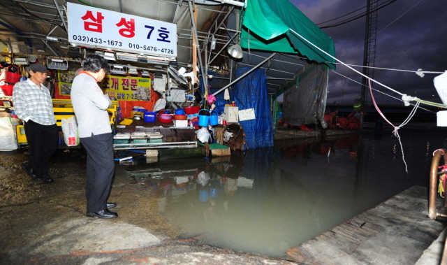 1일 오후 연중 가장 큰 보름달인 이른바 '슈퍼 문' 영향으로 인천 앞바다 만조 해수면 수위가 평소보다 높아진 가운데 인천시 남동구 소래포구 점포 앞으로 바닷물이 차오르자, 나들이객들이 신기한 모습으로 바라보고 있다. 장용준기자