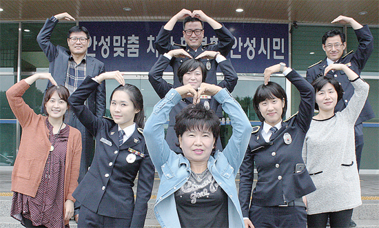 ▲ 경찰, 공무원, 마을이장, 검침원이 사랑의 하트로 밝은 세상을 만들어 줄 것을 권유하고 있다.