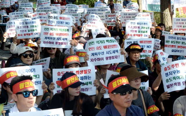 5일 오후 인천시 남동구 인천시청 정문 옆에서 인천송도총연합회 비대위 회원들이 송도 워터 프론트 원안추진을 촉구하는 결의대회를 갖고 있다.장용준기자