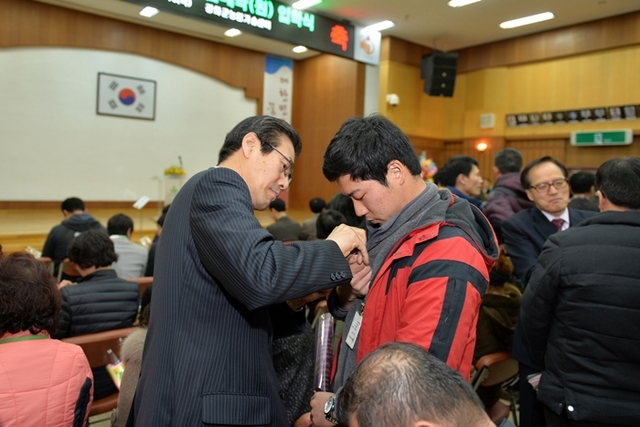 ▲ 이상복 군수가 신입생에게 배지를 달아주고 있다