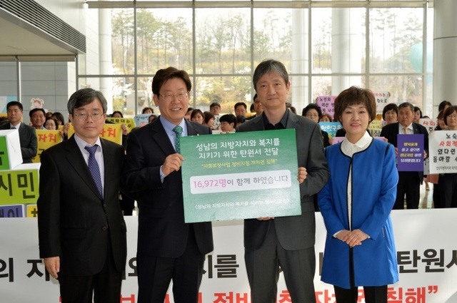 ▲ ‘성남의 지방자치와 복지를 지키기 위한 범시민모임’의 공동대표인 조승문(맨 왼쪽), 안성숙(맨 오른쪽) 회장이 이재명 성남시장(왼쪽에서 2번째)과 권한쟁의심판 청구소송 담당 이찬진 변호사(오른쪽에서 2번째)에게 사회보장 정비지침 반대 탄원서를 전달하고 있다