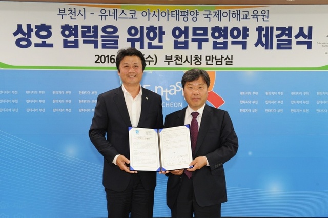 ▲ 상동도서관_김만수 시장과 정우탁 유네스코아시아태평양 국제이해교육원장이 협약서를 보이고 있다.
