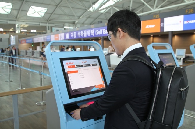 ▲ 인천국제공항 여객터미널 3층에서 제주항공 승객이 직접 자동수하물위탁기기를 이용해 수하물을 위탁하고 있다./인천공항공사 제공