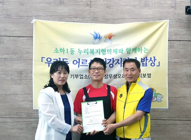 ▲ 지난 1일 광명시 소하1동 누리복지협의체 유정석 대표(가운데)가 도시락 기증 기탁서를 전달하고 있다. 광명시 제공