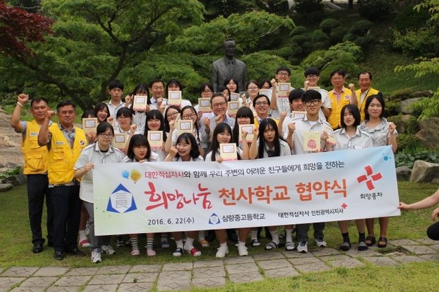 ▲ 황규철 인천적십자 회장과 삼량중고등학교 학생들이 천사학교 협약을 맺고 있다.