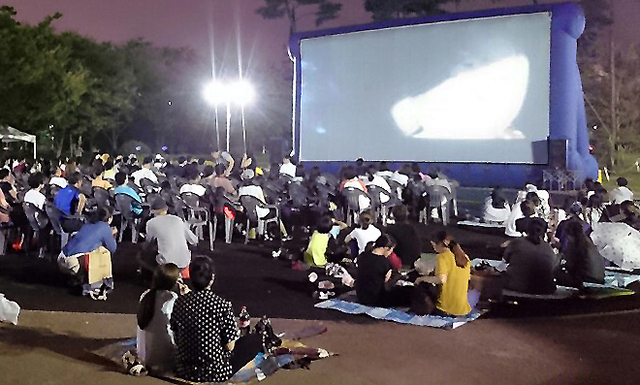▲ 지난 23일, 부평공원 광장에 마련된 대형스크린을 통해 시민들이 무료영화를 관람하며 더위를 식히고 있다.