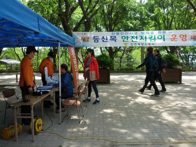 ▲ 계양소방서 등산목 안전지킴이들이 등산객을 상대로 혈압 등 간단한 건강검진서비스를 제공하고 있다. /계양소방서 제공