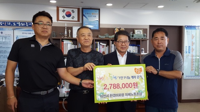 ▲ 이천시 환경미화원 자체노동조합 한식 위원이 조병돈 시장에게 행복한 동행 모금사업에 성금을 기탁하고 있다(사진=이천시)