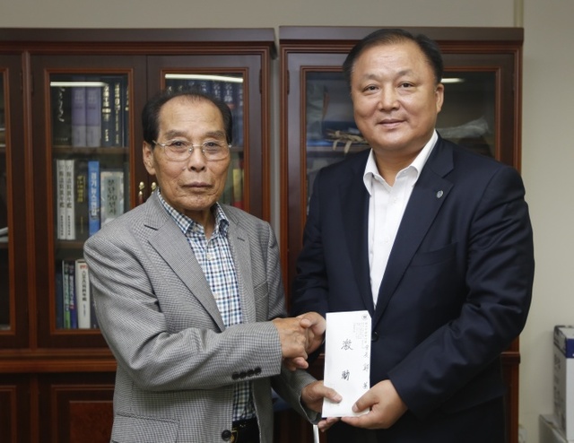 ▲ 정기철 경기도체육인회 회장(왼쪽)이 최규진 도체육회 사무처장에게 격려금을 전달한 뒤 기념촬영을 하고 있다.경기도체육회 제공