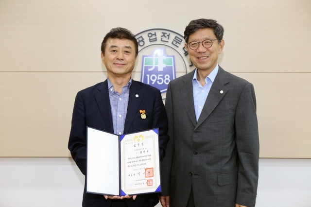 ▲ 홍영식 인하공업전문대학(인하공전) 항공운항과 교수가 지난 2014년 인천 장애인아시아경기대회(APG)에서 국가체육발전에 이바지한 공로를 인정받아 대통령 표창을 수상했다. 홍 교수(왼쪽)와 전인주 인하공전 총장(오른쪽)이 기념촬영을 하고 있다. 인하공전 제공