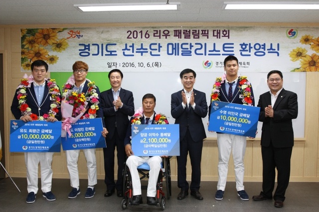 ▲ 이재율 경기도 행정1부지사(왼쪽 세 번째)를 비롯한 내빈들이 리우 패럴림픽 경기도 소속 메달리스트들에게 격려금을 전달한 뒤 기념촬영을 하고 있다.경기도장애인체육회 제공