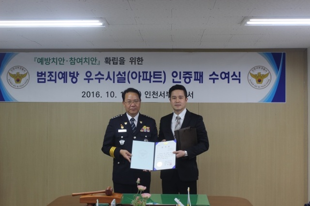▲ 반병욱 인천서부경찰서장(왼쪽)이 박정호 (주)상일테크 사장에게 방범 최우수시설 인증패를 전달한 뒤 기념촬영을 하고 있다
