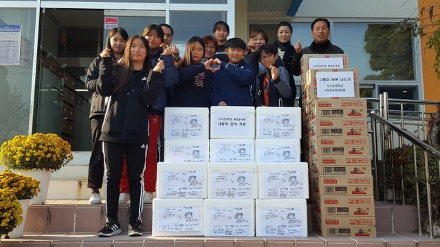 ▲ 이천 도지초교 학생들이 휴경지를 이용해 직접 재배해 담군 김장김치를 불우이웃을 도와주기 백사면에 전달하고 있다.(사진=이천 백사면사무소)