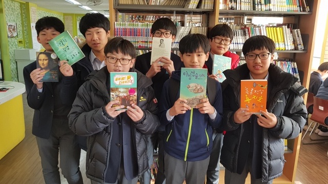 ▲ 신흥중학교 학생들이 인천항만공사가 기증한 '사랑의 책'을 들고 기뻐하고 있다. / 인천항만공사 제공