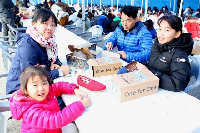 ▲ 12일 관세청의 '희망디자인 축제'에 참여한 한 가족이 짝퉁 운동화의 상표를 제거하는 봉사활동을 하고 있다./인천본부세관 제공
