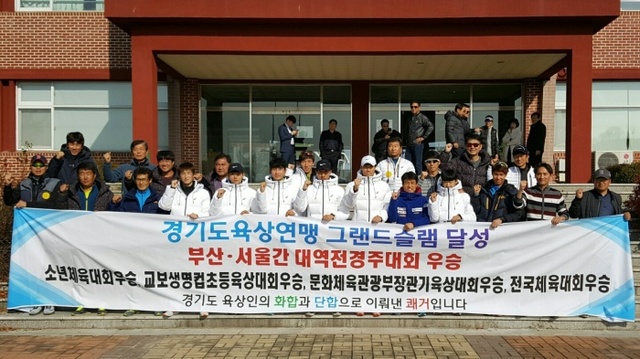▲ 제62회 부산-서울간 대역전경주대회에서 11년 만에 종합우승을 차지한 경기도선수단 임원과 선수들이 플래카드를 펼쳐들고 기념촬영을 하고 있다.경기도육상연맹 제공