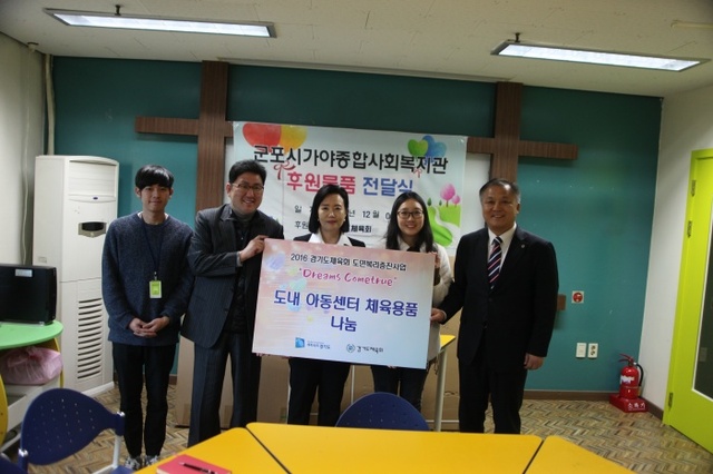 ▲ 정윤경 경기도의회 의원(가운데)과 최규진 도체육회 사무처장(맨 오른쪽)이 군포 가야사회복지관에 체육용품을 전달한 뒤 기념촬영을 하고 있다.경기도체육회 제공