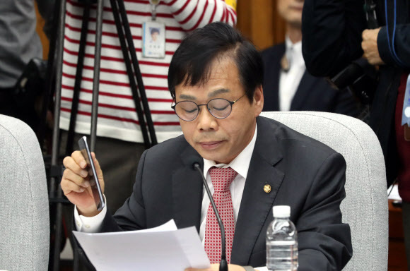 ▲ 사진=연합뉴스, 최순실 국조특위 여당 간사직 사임 신상발언 중 휴대전화를 들어 보이고 있는 이완영 의원